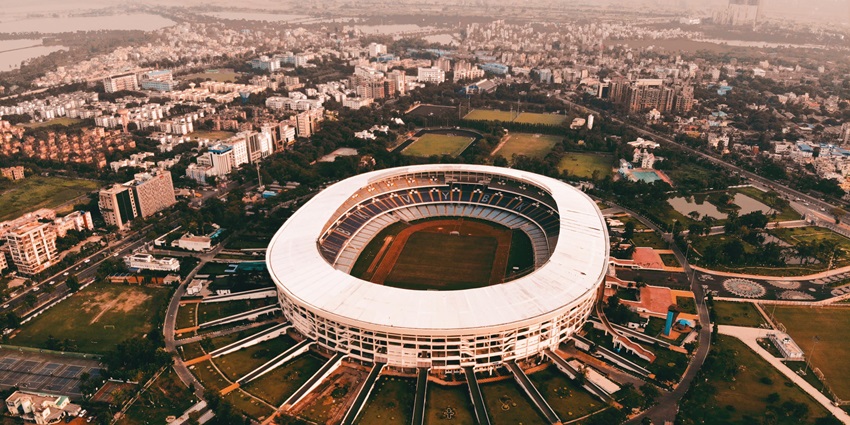 Aerial view of the Stadium with circular structure surrounded by buildings and waterbody