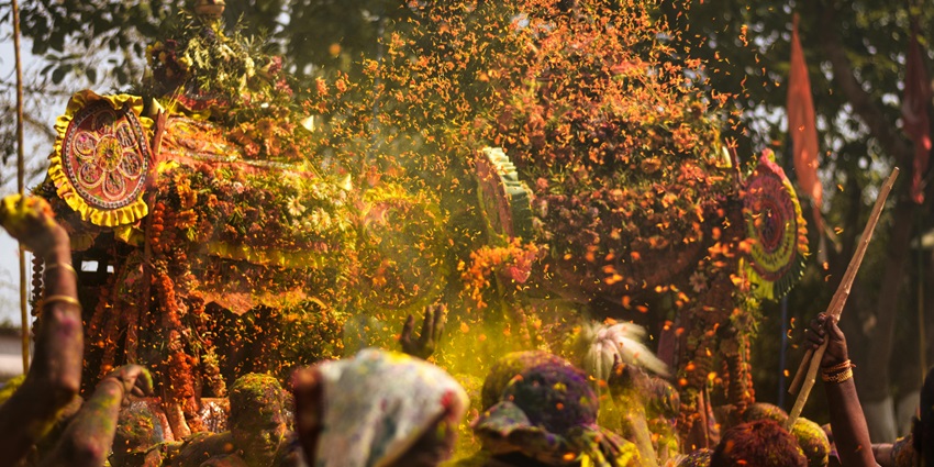 People throw flowers together during Holi Mahotsav at the Banke Bihari Temple.