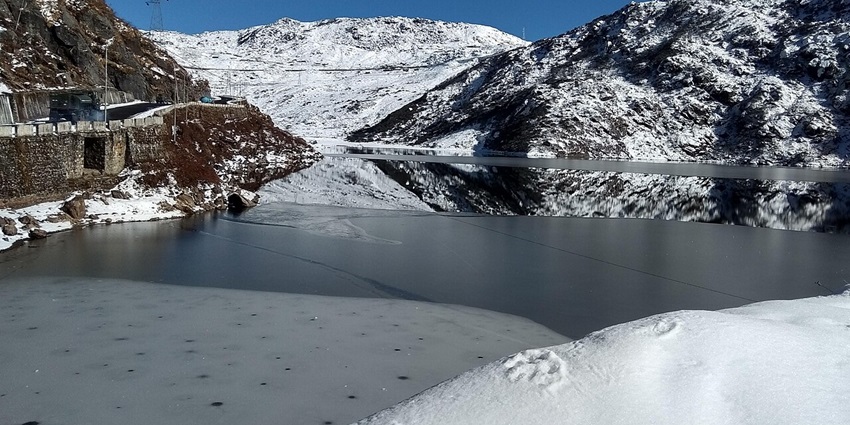 A frozen Chnangu Lake turned into a winter wonderland in December with snowy hills around