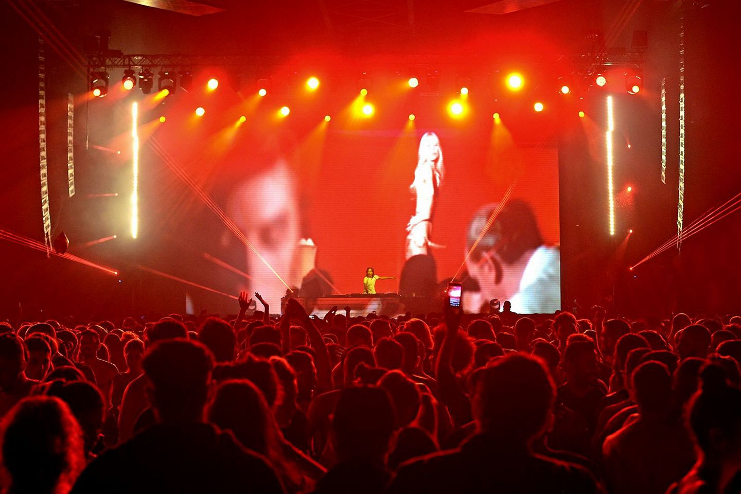 A crowd of people enjoy an electric musical performance during a concert.