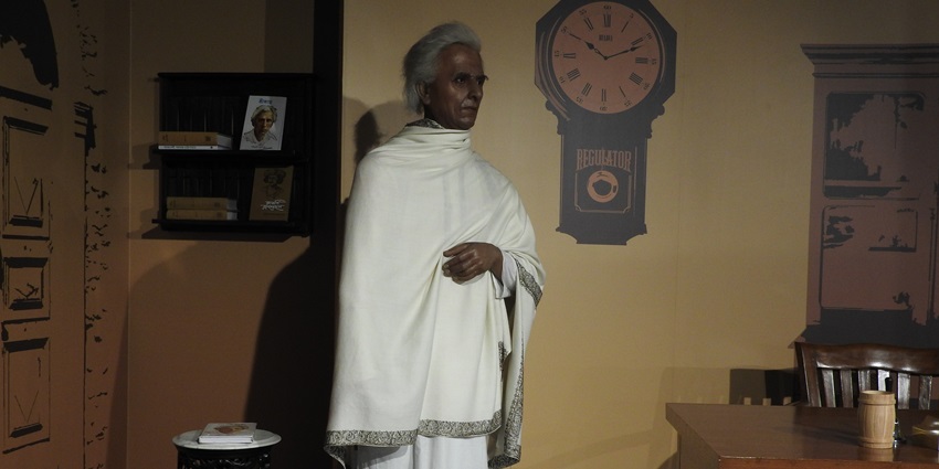 Wax statue of Sarat Chandra Chattopadhyay in traditional attire and his famous novels