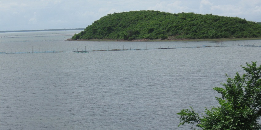 A peaceful island surrounded by turquoise waters and seagrass beds, with a boat anchored near the shore of Honeymoon Island.