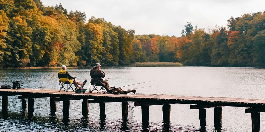 A picture of people fishing by the serene lakeside, one of the top water sports in Lonavala.