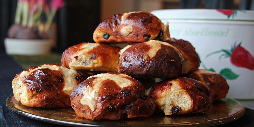 Delicious Hot Cross Buns stacked on one another on a plate