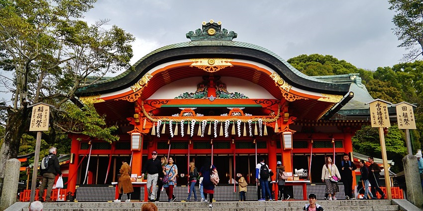 Tourists walking through the Fushimi Inari Taisha, one of the famous Japanese temples.