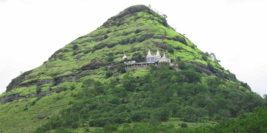 An image of the Jain cave at Gajpantha, surrounded by abundant greenery and natural beauty