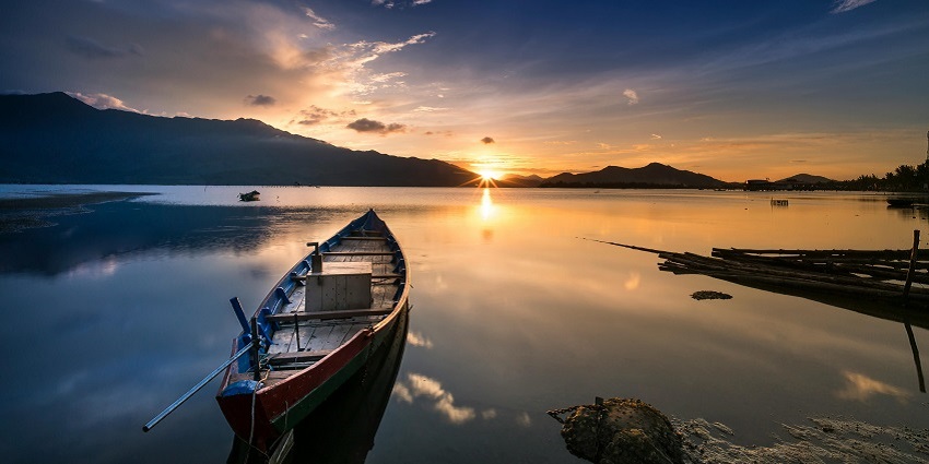 Image of the Empty Gray Canoe Boat Near Shore during Golden Hour