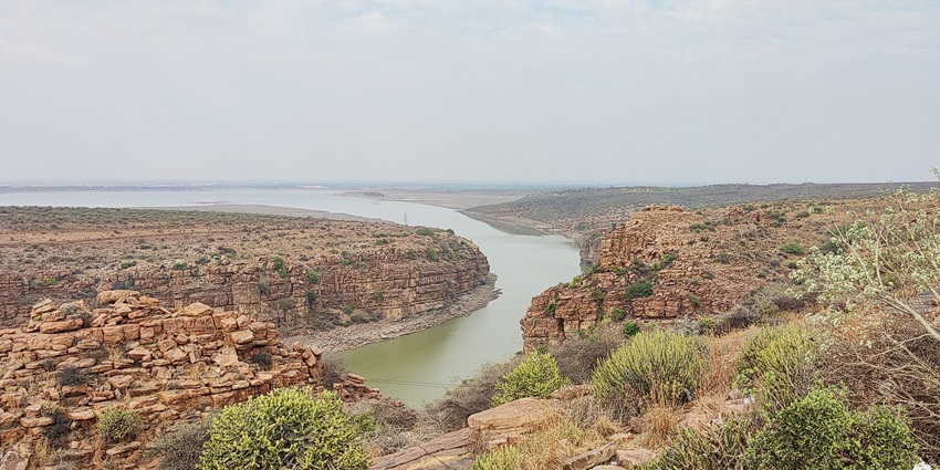 An aerial view of a majestic canyon in Andhra Pradesh with a river flowing through the opening