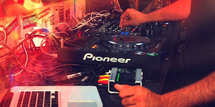 An Image of DJ with the console at a nightclub, resembling the Gibson Club nightlife