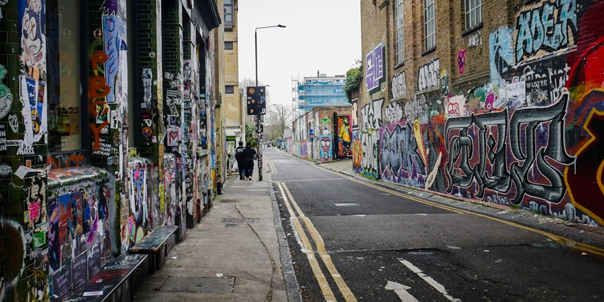 Colorful street art mural on London’s Brick Lane, showing bold shapes and speech bubble