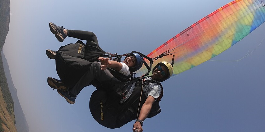 A thrilled couple takes a selfie while paragliding over Kamshet near Pawna Lake.