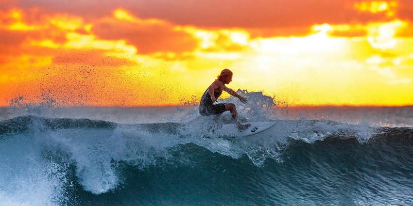 Surfer riding waves at Anse Intendance, one of the popular things to do in Mahé.