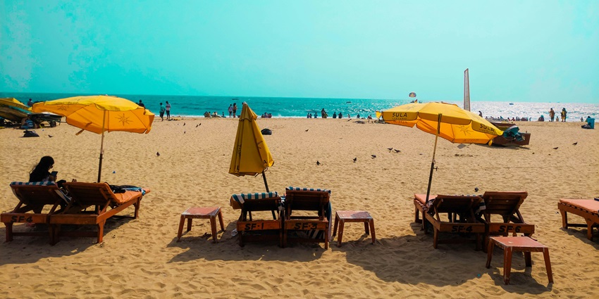 An image showing the Arabian Sea in Goa, India, with waves reaching the shore under a cloudy sky