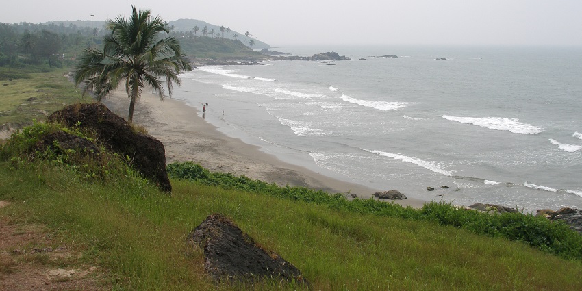 An image of tourists enjoying on the shoreline of the beach of Goa on a foggy day