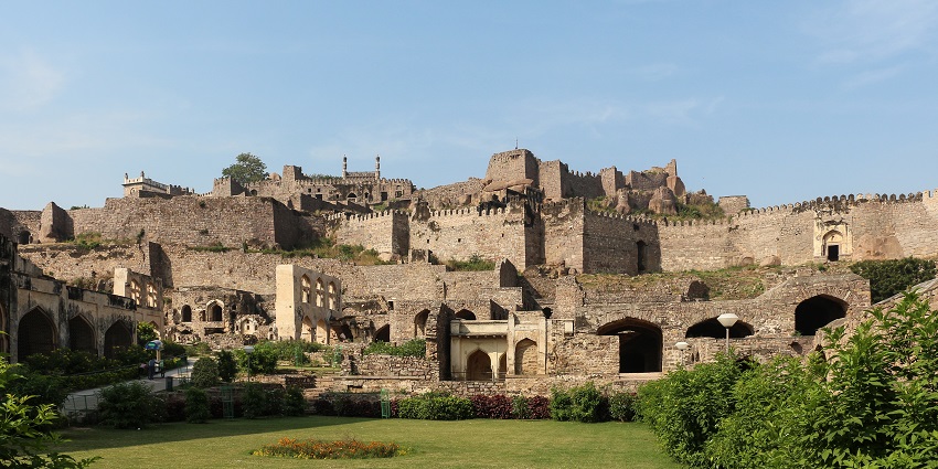 An image of Golconda Fort in Hyderabad, India, showcasing its ancient stone walls and green gardens.