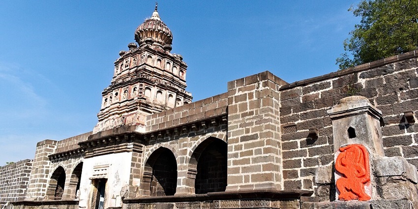 A view of Gomukh Temple near Lonar Lake, an orange-coloured Hanuman deity on the right.