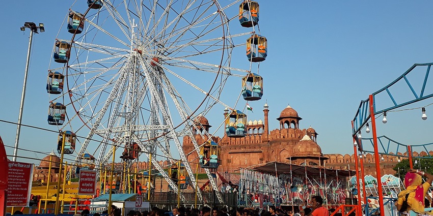 Ferris wheel and crowd at Red Fort Mela, Delhi, with Red Fort in the background