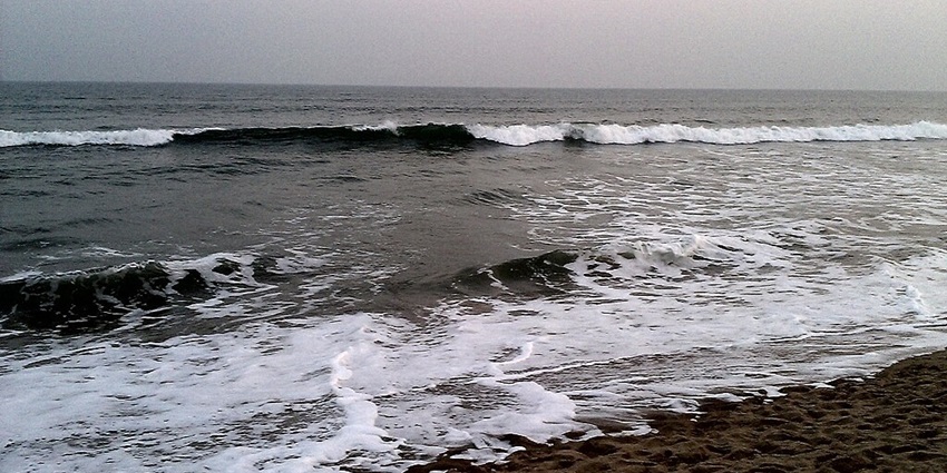 Gopalpur-on-sea beach with low tide waves on the water coming towards the sandy shoreline