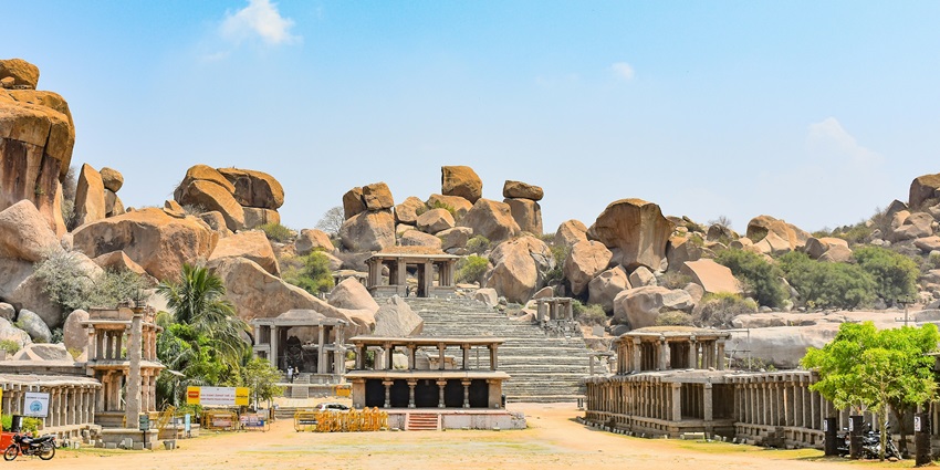 An image of Hampi's ancient stone ruins and temples with clear skies