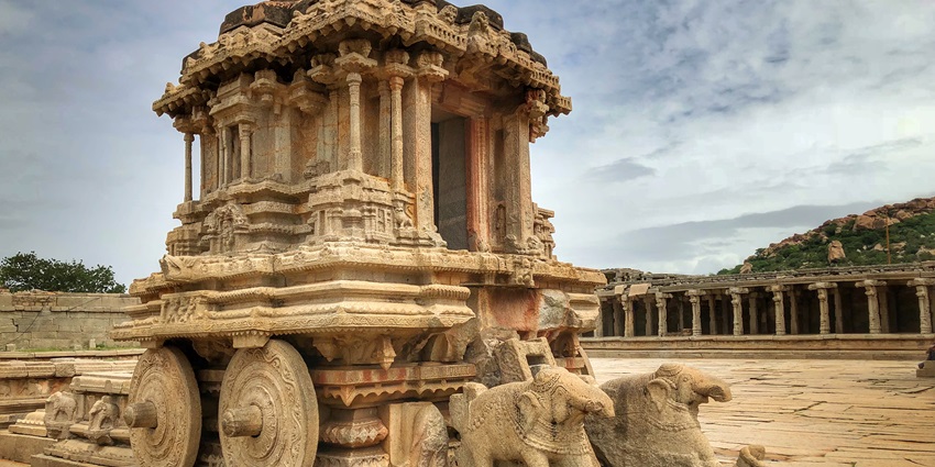 An image showing the Stone Chariot in Hampi, a historic structure with detailed stone carvings.