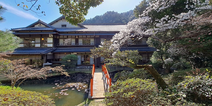 A peaceful view of Hanaikada ryokan, nestled by the river in Kyoto’s scenic Arashiyama