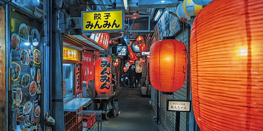 Image of a narrow alley filled with cosy bars, restaurants, and shops