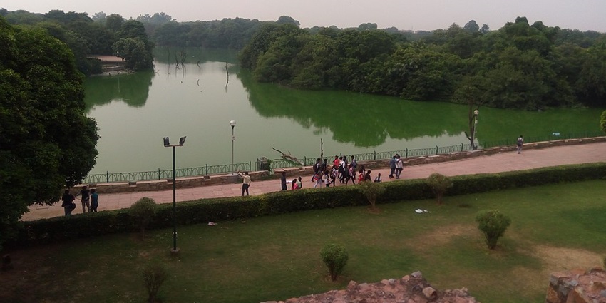 A captivating view of one of the lakes in Delhi, surrounded by historical monuments and lush greenery.