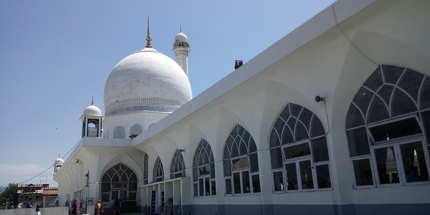 Hazratbal shrine with the traditional white architecture, multiple windows and devotees.
