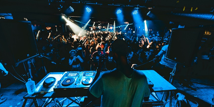 A DJ electrifies the crowd in a vibrant club, capturing the energy of Finland nightlife.