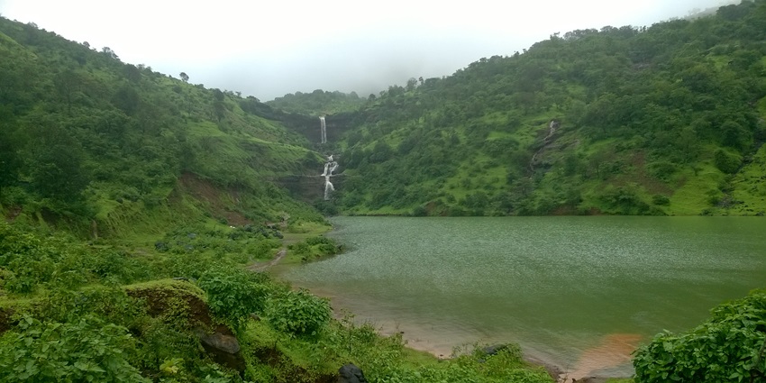 Hidden Lake with the greenish water body in the middle of the greenery and waterfall.