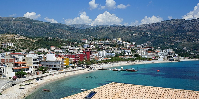 An image of the coastal town of Himara with turquoise sea and hillside houses.