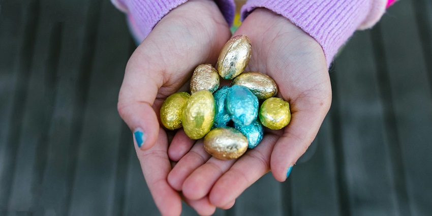 Snapshot of the Hands Holding Chocolate Easter Eggs