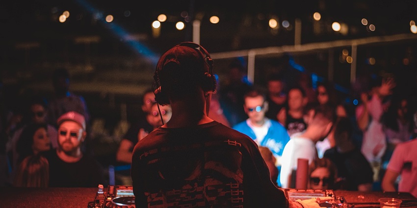 An image showing a DJ performing at a nightclub resembling the Hive's lively vibe