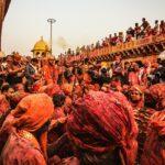 A sea of colour drenched people during Holi Mahostav at Radha Krishna Temple in Vrindavan.