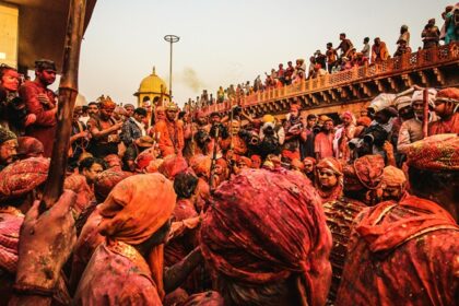 A sea of colour drenched people during Holi Mahostav at Radha Krishna Temple in Vrindavan.