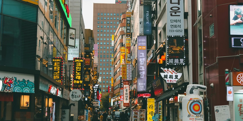 Bustling street with clubs, bars, and street performances.