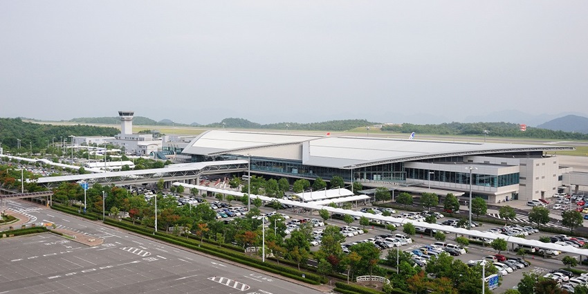 A view of Hiroshima Airport with lights illuminating the runway and terminal in the distance.