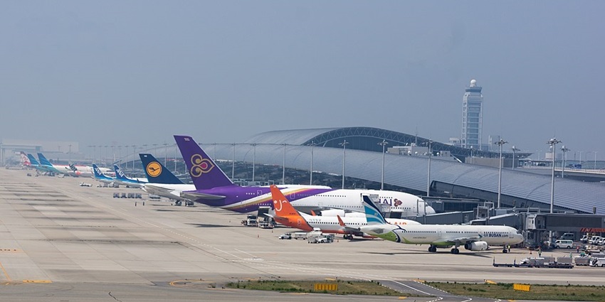 Kansai International Airport terminal with multiple aeroplanes parked and transportation.