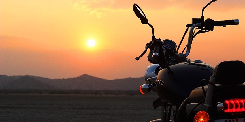 Royal enfield bike parked near the Sambhar Lake during a sunset and distant hills