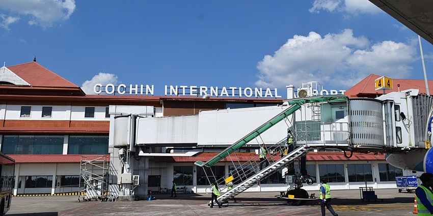 Cochin International Airport terminal with a jet bridge extending to an airplane