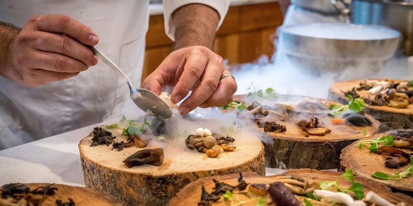 An image showing a chef carefully preparing a vegetable dish with fresh ingredients.