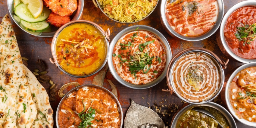 A visually stunning image showcasing a wide array of colourful and aromatic Indian dishes.