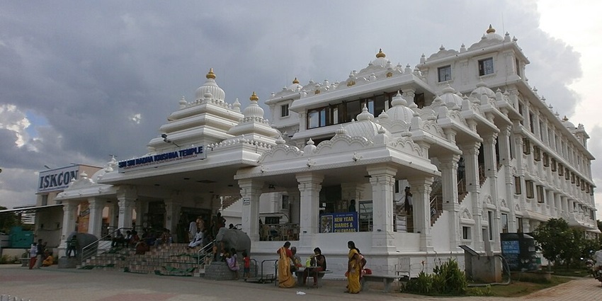 Iskcon temple of Chennai with white building architecture and devotees visiting the temple