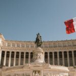 An image of the Monument to Victor Emmanuel II in Rome, Italy, with Italian flags flying.