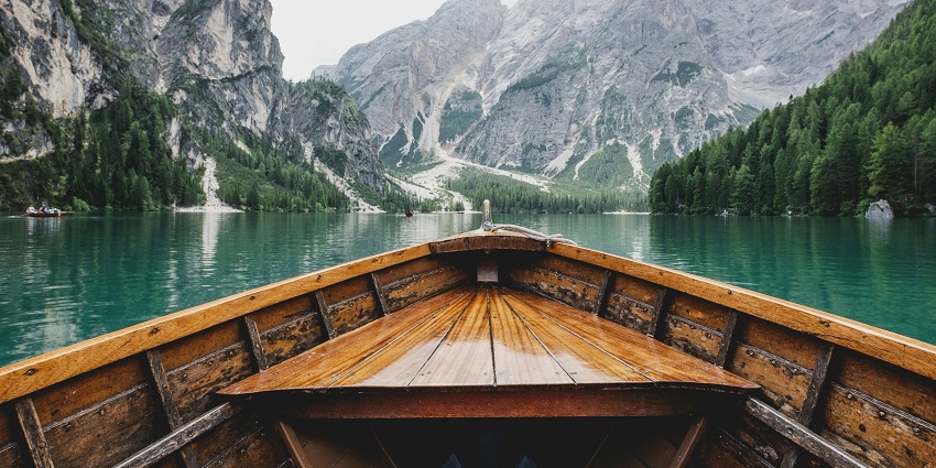 An image of a Lake with a boat on it, surrounded by mountains similar to Jadar lake