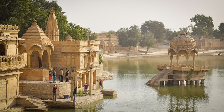 An image of the Jaisalmer Fort, made of golden stone, with the desert around it.