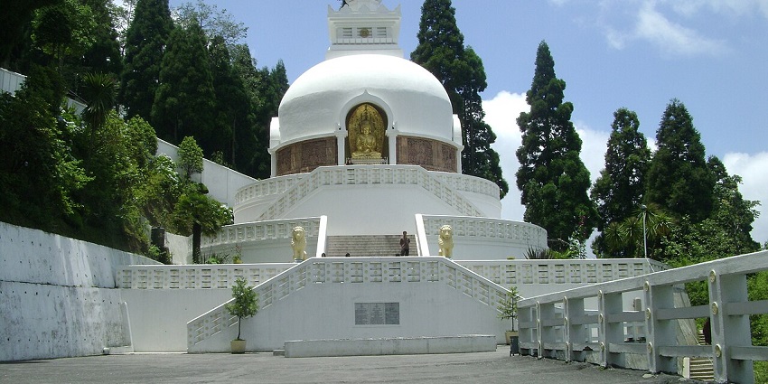View of the Japanese Temple with lush tres and clear blue sky in the background.
