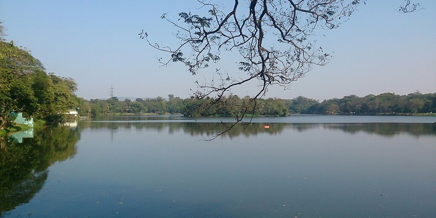 Jubilee Lake with a large still water body, distant buildings and surrounded by greenery