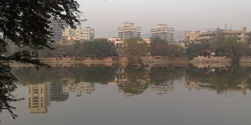 An image of Kachrali Lake with a temple and lush greenery in the background.