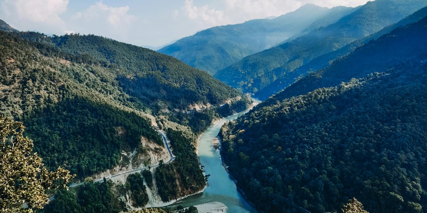 River winding through a lush green valley with mountains in Kalimpong, West Bengal
